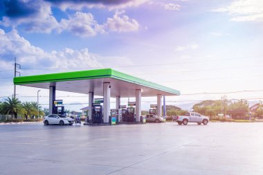 Bulutları ve mavi gökyüzü olan benzin istasyonu