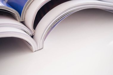 Oturma odasındaki beyaz masaya yığılmış dergiler yığını, kapatın.