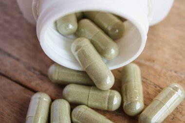 Şişeden dökülen bitkisel kapsüller.