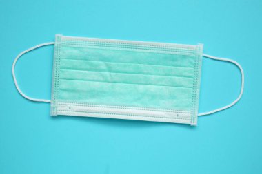 Mavi arka plan korumalı cerrahi yüz maskesi COVID-19 Coronavirus 'a karşı. Sağlık ve Tıp Konsepti