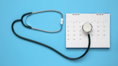 Stetoskop ile takvim sayfası mavi arka plan doktor randevu konsepti