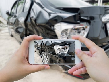 Fotoğraf çeken akıllı telefondan araba kazası zarar görmüş.