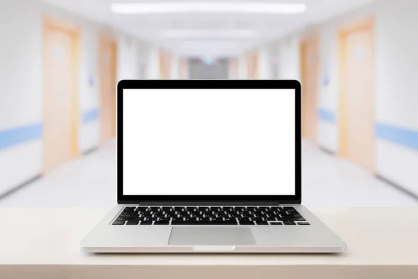 Laptop computer on medical table with hospital background