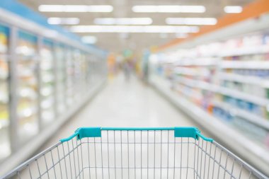 Süpermarket koridoru soyut bulanık dondurulmuş ve buzdolabı raflarında süt ürünleri olan alışveriş arabası görüntüsü arka planda