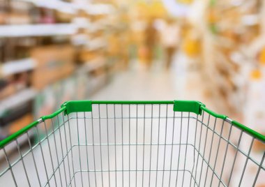 Market koridorlu alışveriş arabası. Arkaplanda bulanık ürünler var.