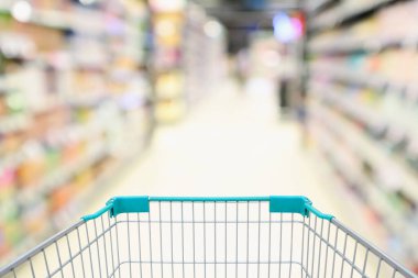 Boş yeşil alışveriş arabası arka planına sahip bulanık süpermarket koridoru