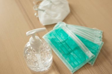 Covid-19 Coronavirus önleme konsepti için ahşap masaya alkol dezenfektanlı yüz maskesi.