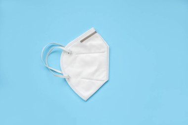 KN95 yüz maskesi, 2.5 polution ve COVID-19 coronavirus 'a karşı mavi arka plan korumasında. Sağlık ve Tıp Konsepti