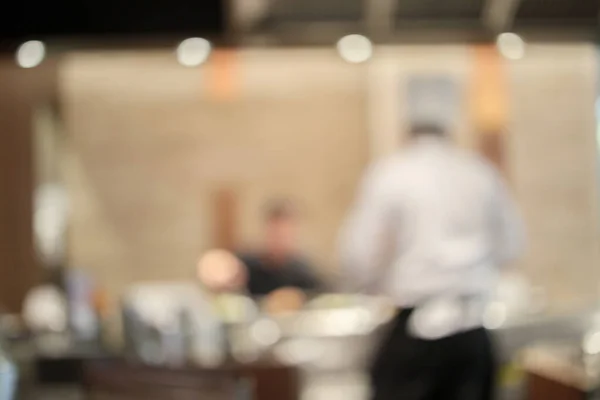 Chef cooking in restaurant kitchen abstract blurred defocused background