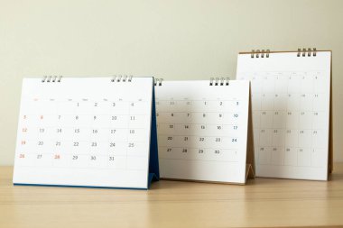 Takvim sayfası beyaz duvar arkaplanlı ahşap masaya yakın