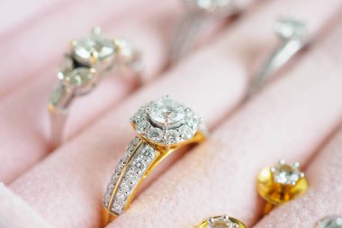 Altın ve gümüş elmas yüzük ve küpeler lüks mücevher kutusunda.