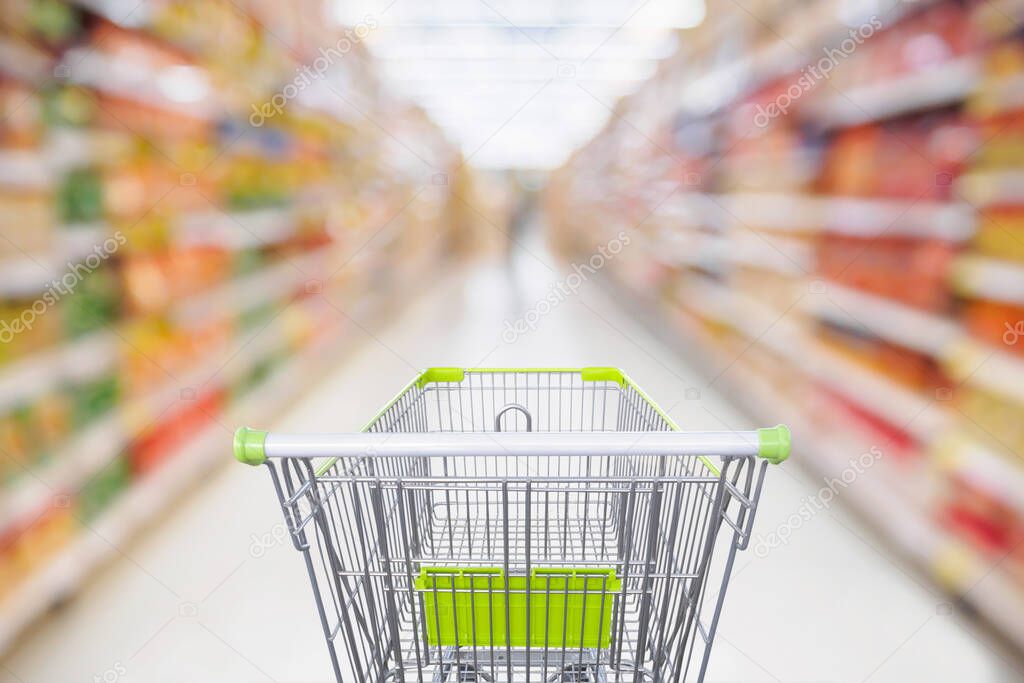 Supermarket aisle with empty shopping cart at grocery store retail business concept