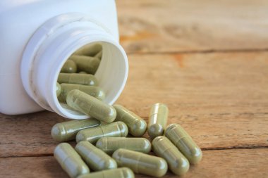 Şişeden dökülen bitkisel kapsüller.