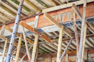 Bambu iskelesi inşaat alanındaki beton kirişi destekliyor.