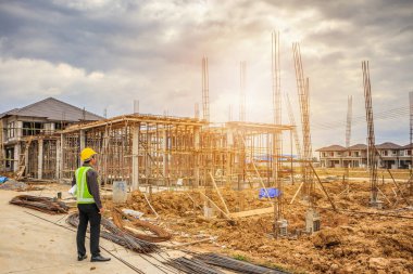 Asyalı işadamı inşaat mühendisi koruyucu miğfer ve bina inşaatında kullanılacak planlar.