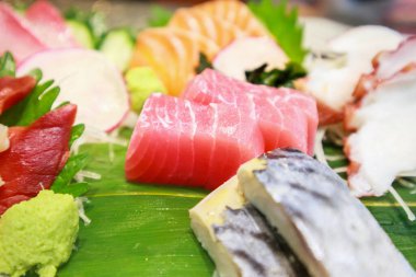 Somon, saba, tako ve bambu yapraklı hokkigai saşimi ile ton balığı dilimi.