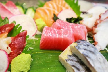 Somon, saba, tako ve bambu yapraklı hokkigai saşimi ile ton balığı dilimi.