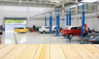 Araç servis merkezinin üzerinde boş ahşap masa ve tamir istasyonunda otomatik olarak bokeh ışığı odaklanmış bulanık arkaplan