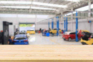 Araç servis merkezinin üzerinde boş ahşap masa ve tamir istasyonunda otomatik olarak bokeh ışığı odaklanmış bulanık arkaplan