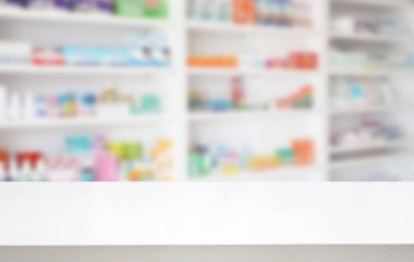 Eczane arka planında bulanık ilaç rafları bulunan boş beyaz eczane ürün tezgahı