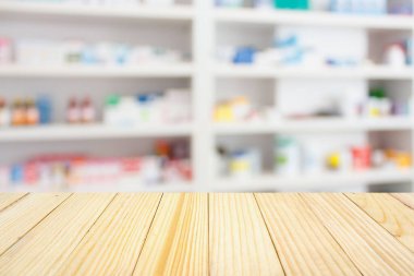 Eczane tezgahı, raflarda ilaç ve sağlık ürünleri olan soyut, bulanık arka plan.