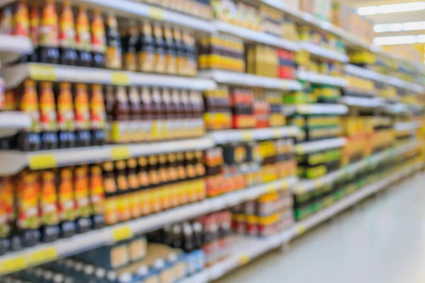 Arkaplan için raflarda bulanık ürün bulunan süpermarket koridoru