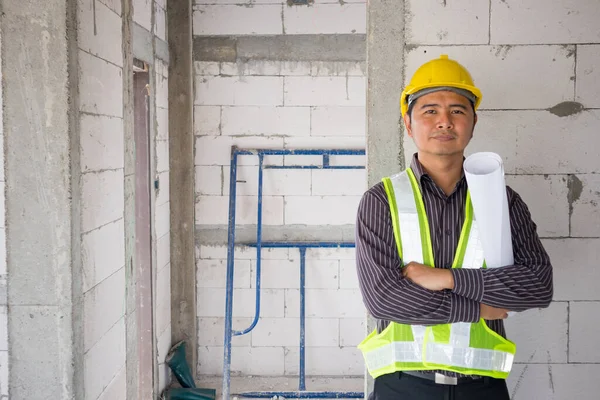在房屋建筑工地手握防护头盔和蓝图纸的亚洲商人 建筑工程师 — 图库照片