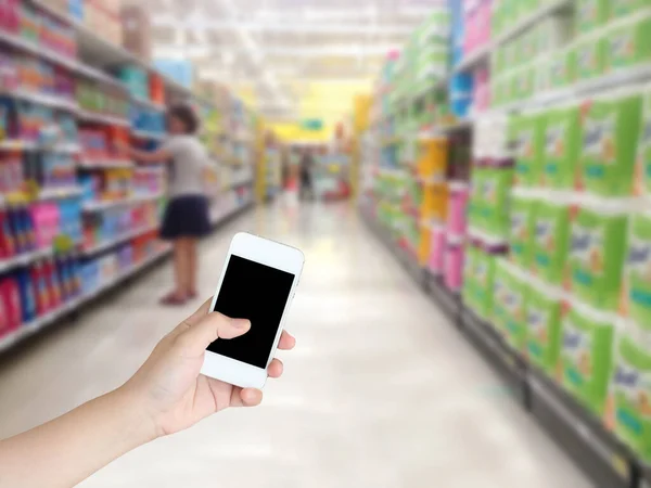 Mão Segurando Telefone Celular Com Prateleiras Supermercado Corredor Desfocado Fundo — Fotografia de Stock