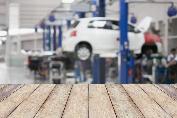 製品の表示やモンタージュのためのブラーガレージの背景を持つ木製テーブルトップあなたの製品 — ストック写真