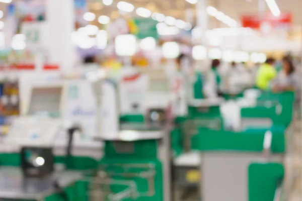 supermarket checkout payment terminal with customers blurred background