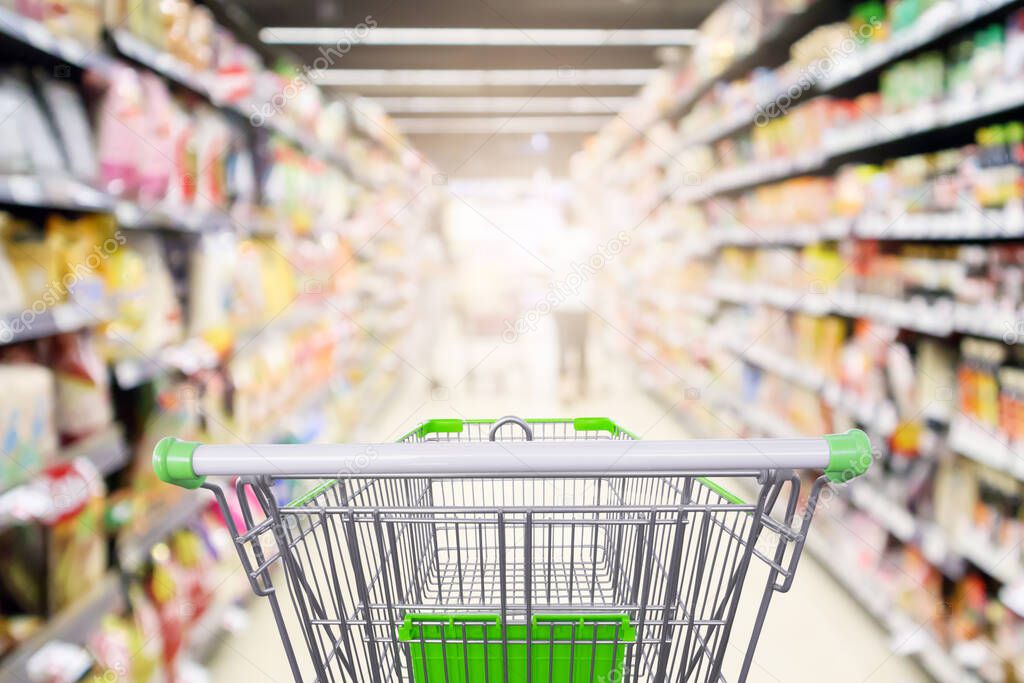 supermarket shelves aisle with empty shopping cart defocused interior blur bokeh light background