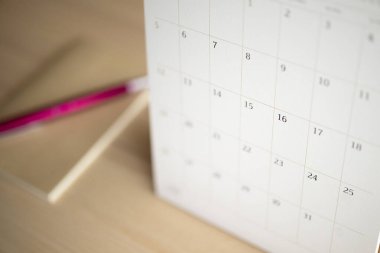 Takvim sayfası ahşap masa arkaplanını kalem ve defter iş randevusu planlama konseptiyle kapat