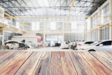 Ahşap masa üstü ve araba tamir merkezi iç kısmı bulanık. Montaj otomatik ürün görüntüsü yaratmak için.