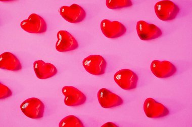 Sevgililer Günü geçmişi, pembe arka planda kalp şeklinde şekerler.