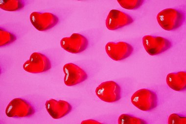 Sevgililer Günü geçmişi, pembe arka planda kalp şeklinde şekerler.