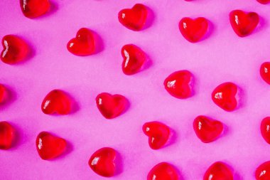 Sevgililer Günü geçmişi, pembe arka planda kalp şeklinde şekerler.