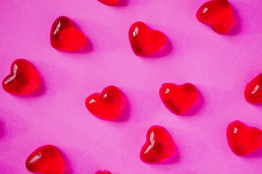 Sevgililer Günü geçmişi, pembe arka planda kalp şeklinde şekerler.