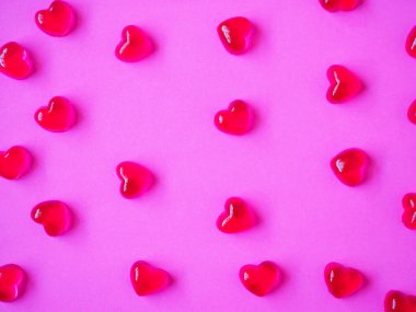 Sevgililer Günü geçmişi, pembe arka planda kalp şeklinde şekerler.