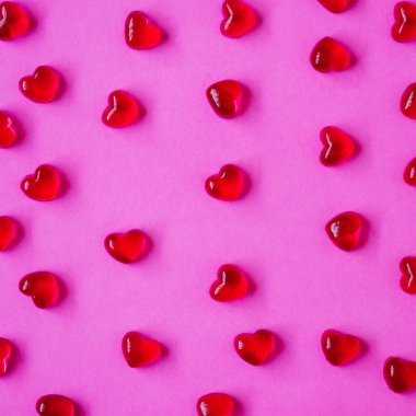 Sevgililer Günü geçmişi, pembe arka planda kalp şeklinde şekerler.