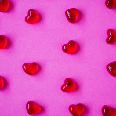 Sevgililer Günü geçmişi, pembe arka planda kalp şeklinde şekerler.