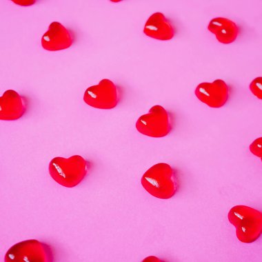 Sevgililer Günü geçmişi, pembe arka planda kalp şeklinde şekerler.