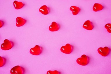 Sevgililer Günü geçmişi, pembe arka planda kalp şeklinde şekerler.