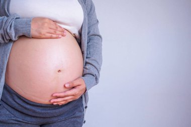 Hamile kadın karnına dokunuyor.