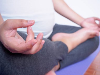 Hamile kadın evde yoga yapıyor.