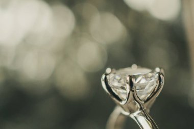 Soyut bokeh ışık arkaplanlı lüks nişan yüzüğü
