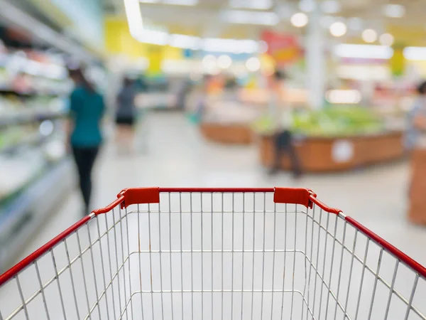 Shopping cart with Grocery store blur background with customers