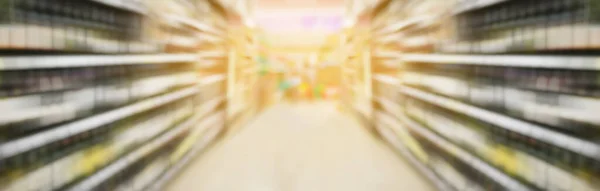 wine bottles on liquor shelves in supermarket with motion blur panorama view