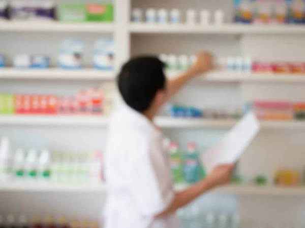 Imagen Borrosa Del Farmacéutico Tomando Medicamentos Estantería Farmacia —  Fotos de Stock