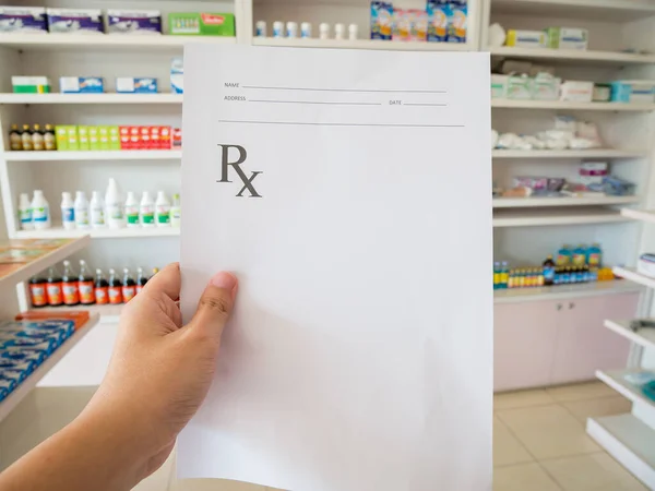 closeup hand of pharmacist with prescription at the pharmacy