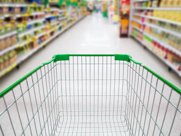 Supermarket interior, supermarket aisle with empty green shopping cart background, shopping in supermarket concept